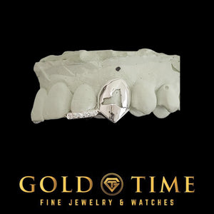 White gold double cap grillz with an open face state cut-out canine and moissanite tip incisor on a dental mold