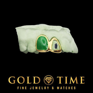 Two piece grillz with a jade tone green incisor cap and yellow gold open face canine on a green dental model