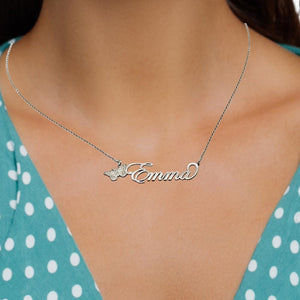 Person wearing a silver cursive butterfly name necklace at the collarbone