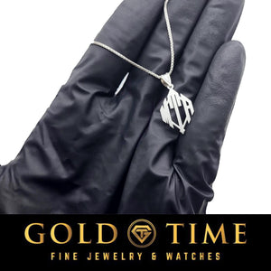 Sterling silver monogram pendant on a chain held between gloved fingers