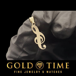 Yellow gold treble clef name pendant resting on a gloved hand against black