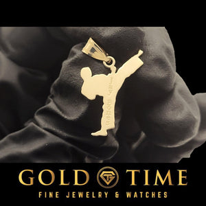 Gold personalized martial arts side kick pendant held in a black gloved hand