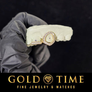 Gloved hand holding a mold with a rose gold iced open face canine and incisor tip double cap