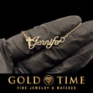 Yellow gold Cross Luxe script name necklace reading Jennifer, with a cross worked into the capital J, held in a gloved hand
