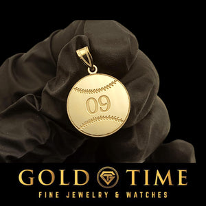 Gold baseball pendant with engraved jersey number 09 and stitching detail, held in a black gloved hand
