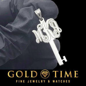 White gold key pendant with a three letter script monogram forming the key bow