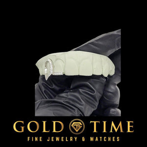 White metal iced open face canine and stone set tip double cap grill shown on a top mold