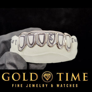 White gold or silver open face grillz on a top dental mold