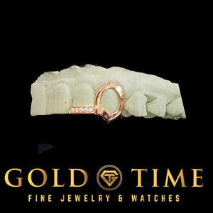 Rose gold open face fang double cap with moissanite incisor tip on a dental mold