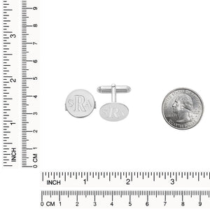 White round monogram cuff links beside a quarter with inch and centimeter rulers