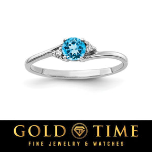 14k white gold bypass ring with a round bright blue gemstone and diamond accents