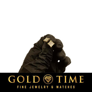 Gloved hand holding a yellow gold kite square diamond stud