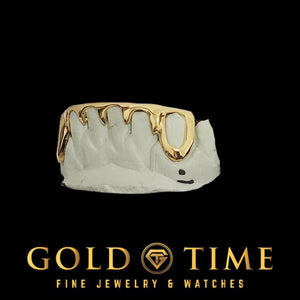 Front view of 6 piece gold bottom grillz with open face canines and spike tips on a mold