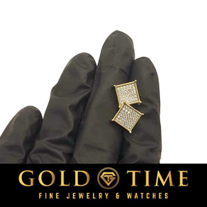 Yellow gold diamond square cluster studs on gloved fingers, closer view