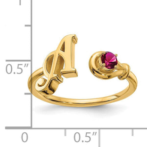 Yellow gold initial birthstone ring measured against a ruler