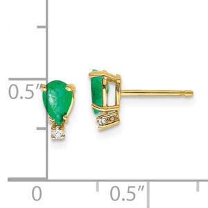 Yellow gold pear cut emerald stud beside a ruler, measuring about a third of an inch