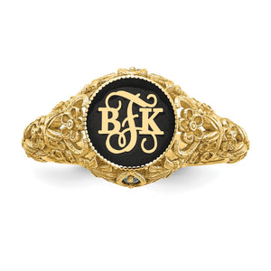 Close up of the yellow gold floral ring face with BJK script monogram raised over black enamel