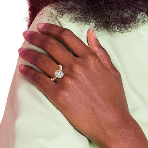 Yellow gold oval halo engagement ring worn on a hand