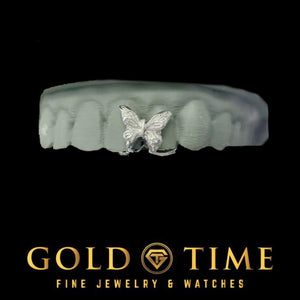 White gold butterfly gap grillz piece sitting between the front teeth of a grey dental model