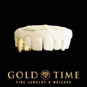 Front view of gold fang and diagonal incisor grillz on a top dental mold