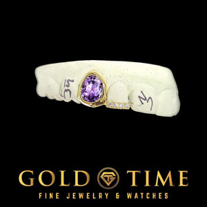 Gold double cap grill with a bezel-set purple oval gem and a moissanite incisor tip on a dental mold