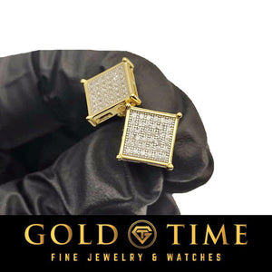 Yellow gold diamond square cluster studs resting in a black gloved hand