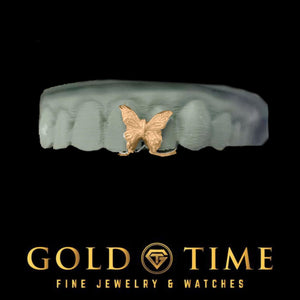 Rose gold butterfly gap grillz piece sitting between the front teeth of a grey dental model