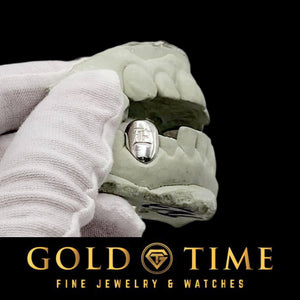 Gloved hand holding a mold with a white metal single cap engraved with an Old English letter