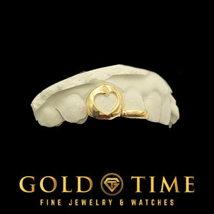 Yellow gold heart cut-out and solid tip double cap on a white dental mold