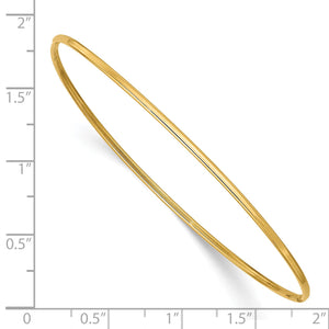 Polished yellow gold bangle beside a ruler showing its width