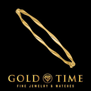 Yellow gold twisted hinged bangle on black