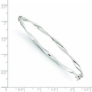 White gold twisted bangle beside a ruler showing its size
