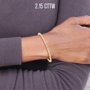 Wrist wearing a 2.15 cttw yellow gold diamond tennis bracelet