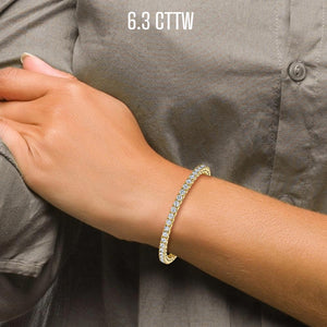 Wrist wearing a 6.3 cttw yellow gold diamond tennis bracelet