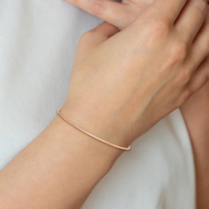 Wrist wearing a polished rose gold bangle