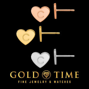 Initial heart stud earrings engraved with C in rose, yellow, and white, shown with their posts on black