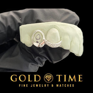 White double cap grillz with an open face canine and an incisor cap with a curved moissanite tip, on a dental mold