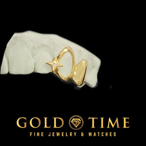 Yellow gold 2 piece grillz on a dental mold: an open face cap with a small moissanite North Star at the gap edge, joined to a solid cap
