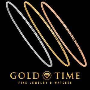 Three thin diamond-cut bangles in white, yellow, and rose gold, shown on black