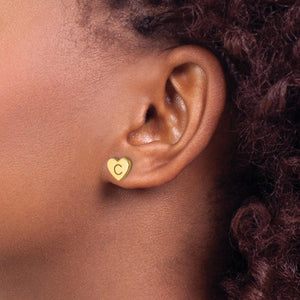 Ear wearing a yellow gold initial heart stud earring