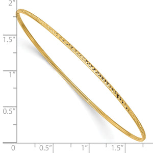 Yellow gold diamond-cut bangle beside a ruler showing its width