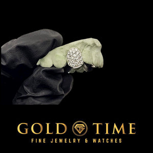 White moissanite honeycomb single cap on one front tooth of a dental mold held in a gloved hand