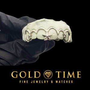Silver frameless open face grillz on a mold, showing the hooked tooth outlines and 3D star accents