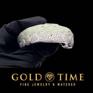 Fully iced 10 piece star cluster grillz in white with moissanite clusters and perm cut edges, on a dental mold in a gloved hand