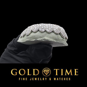 White 10 piece star cluster moissanite grillz on a dental mold held in a gloved hand, side view
