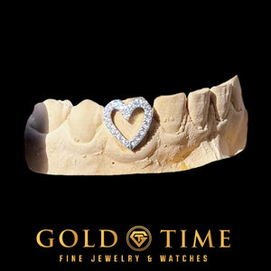 Close view of a white moissanite open heart single cap on a dental mold, with the natural tooth showing through the center