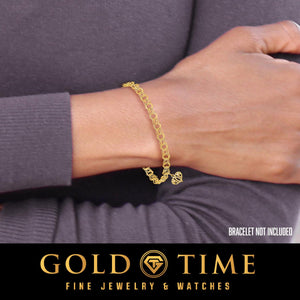 Wrist wearing a yellow gold Mom heart charm on a bracelet; bracelet not included