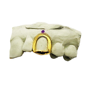 Yellow gold open face single tooth grill with a polished frame on a dental mold