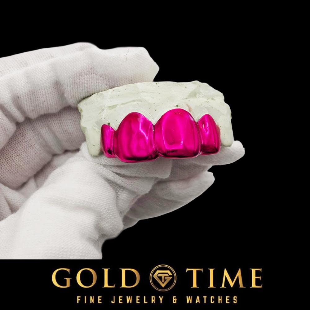 Side view of a Neon Rose pink chrome grill on a mold in a white gloved hand
