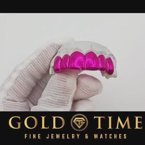 Video of Neon Rose pink chrome grillz turned on a dental mold in a white gloved hand